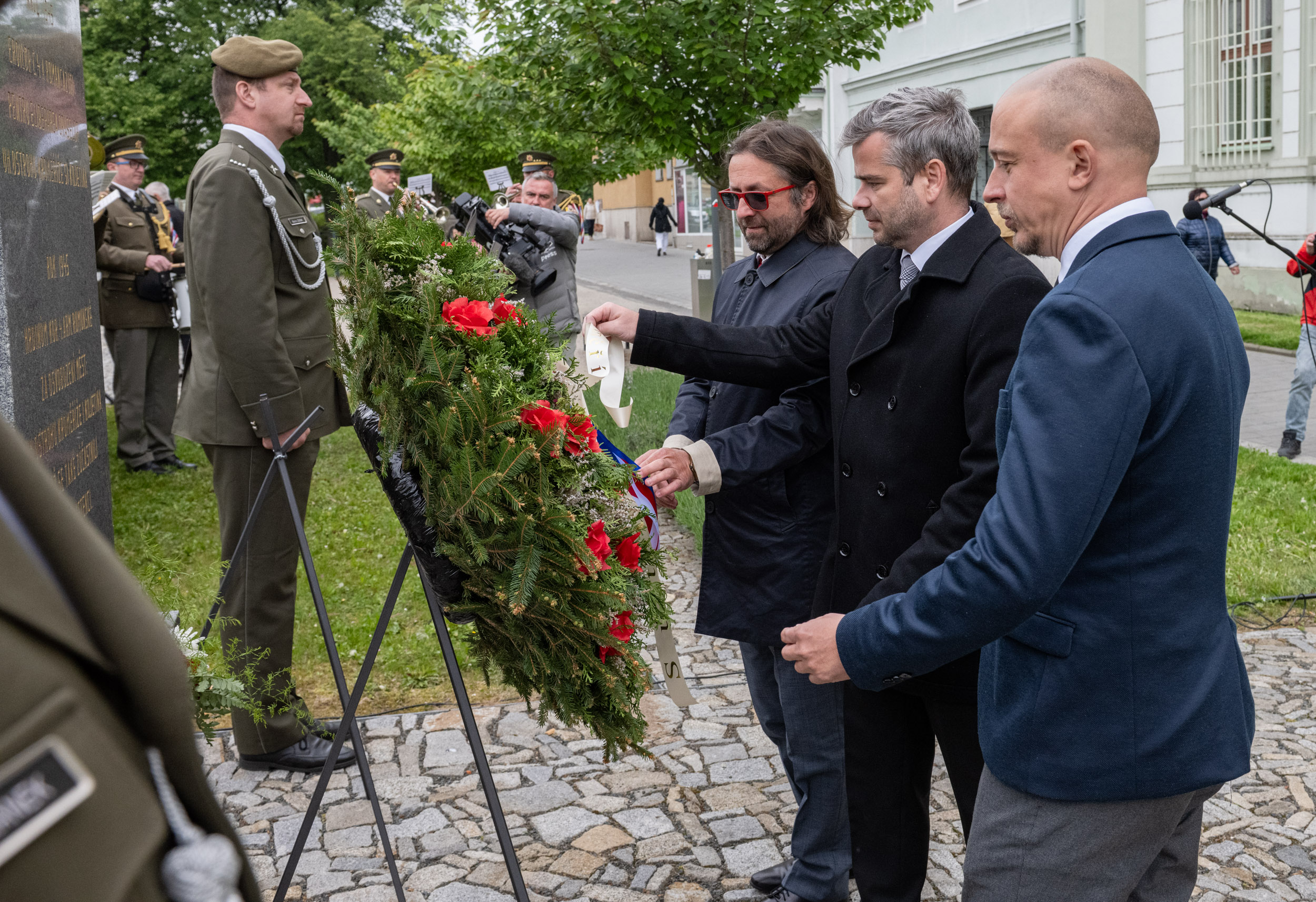 Věnec upravují místostarosta Karel Holík, starosta Tomáš Opatrný a místostarosta Jan Hebnar.
